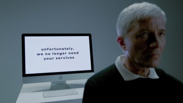 Elderly man and screen with information that his services are no longer needed